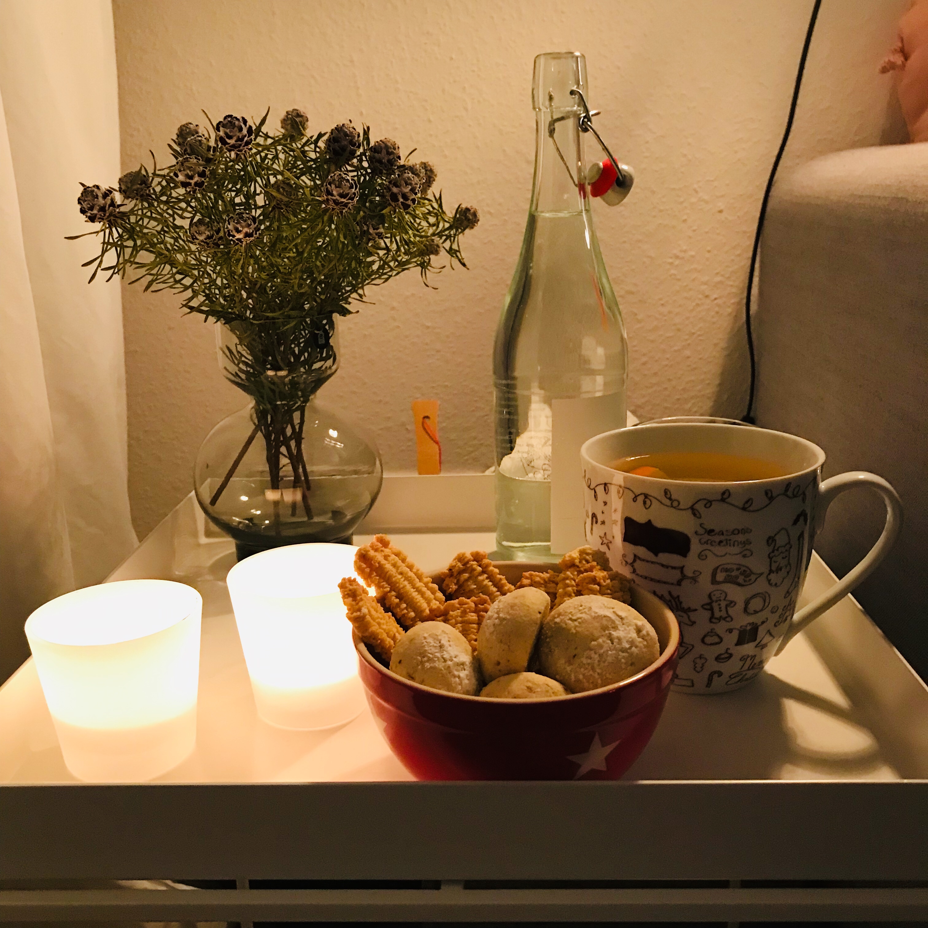 Kekse auf dem Tisch mit Kerzen und Tee