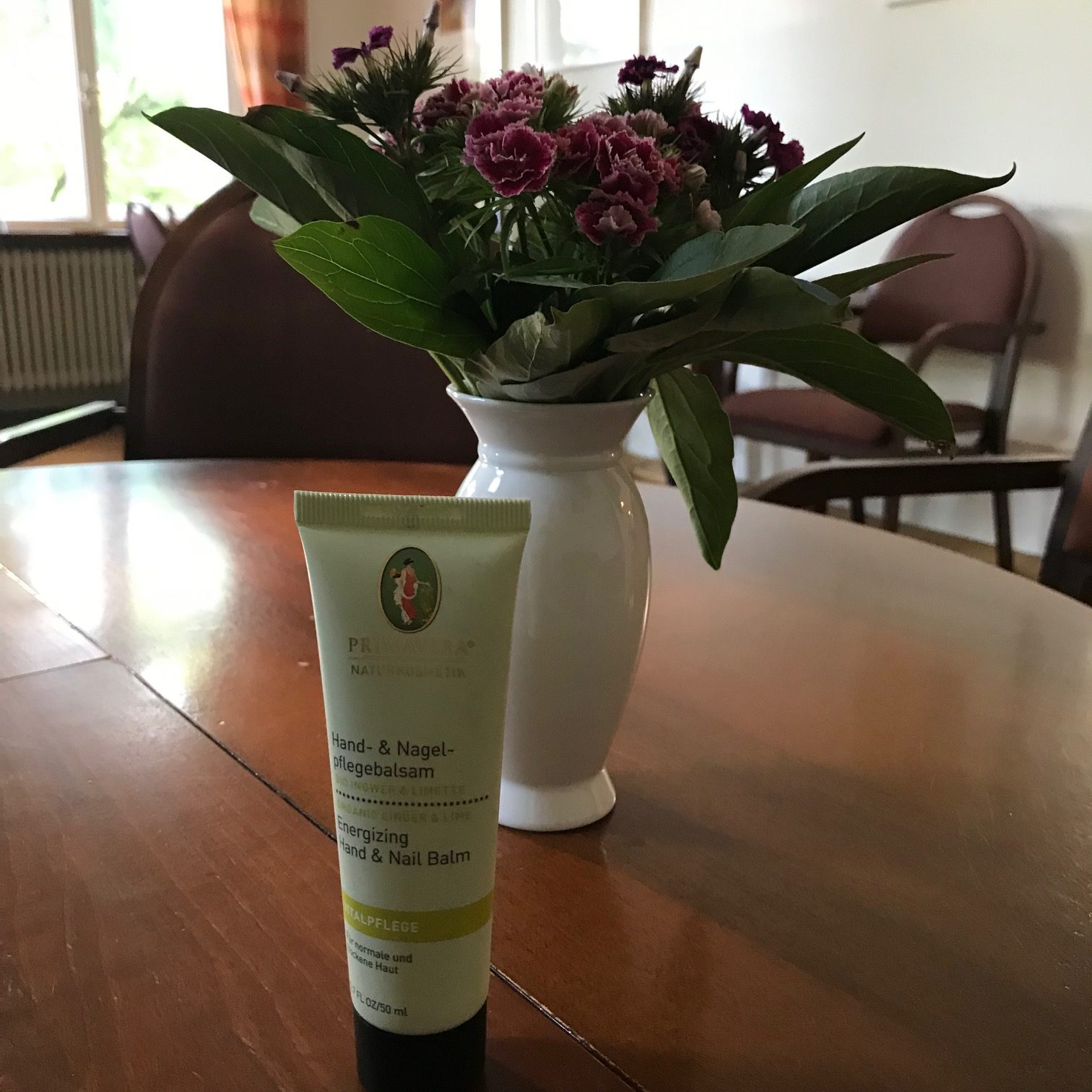 Handcreme Primavera vor einem Blumenstrauss