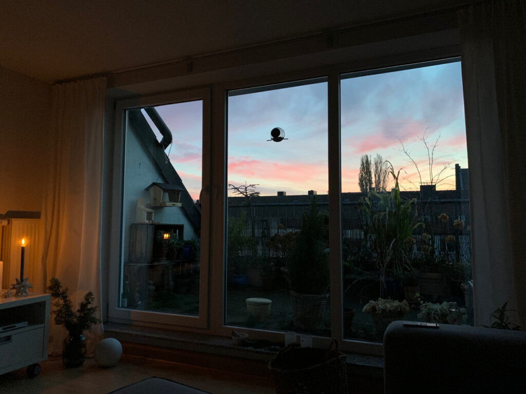 Auf den Sonnenaufgang warten: Hellblauer Himmel mit rosa Wolken