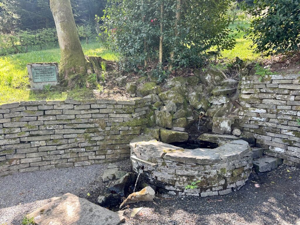 Die Volmequelle: Eine Steinmauer mit einem rund gemauerten Becken, wo das erste Wasser der Quelle reinläuft. Daraus fliesst es weiter und wir dein paar Meter unterirdisch geführt.