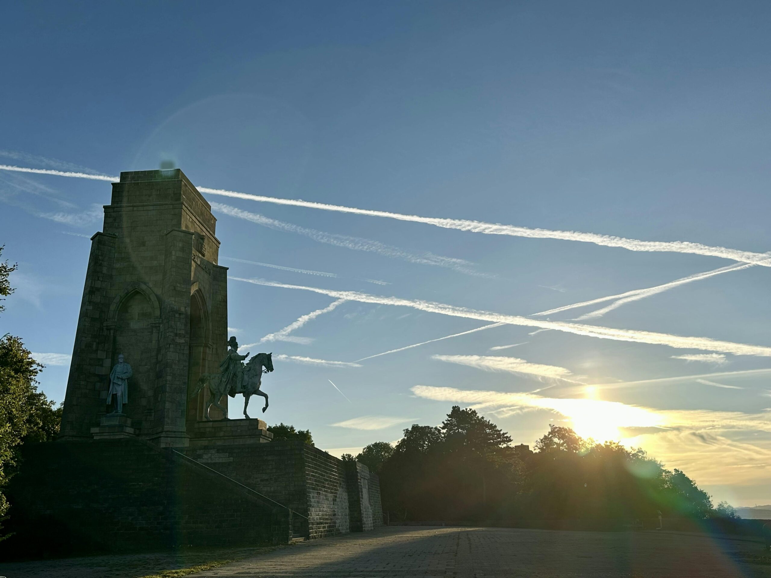 Foto vom Kaiser-Wilhelm-Denkmal an der Hohensyburg in Dortmund im Gegenlicht der aufgehenden Sonne.