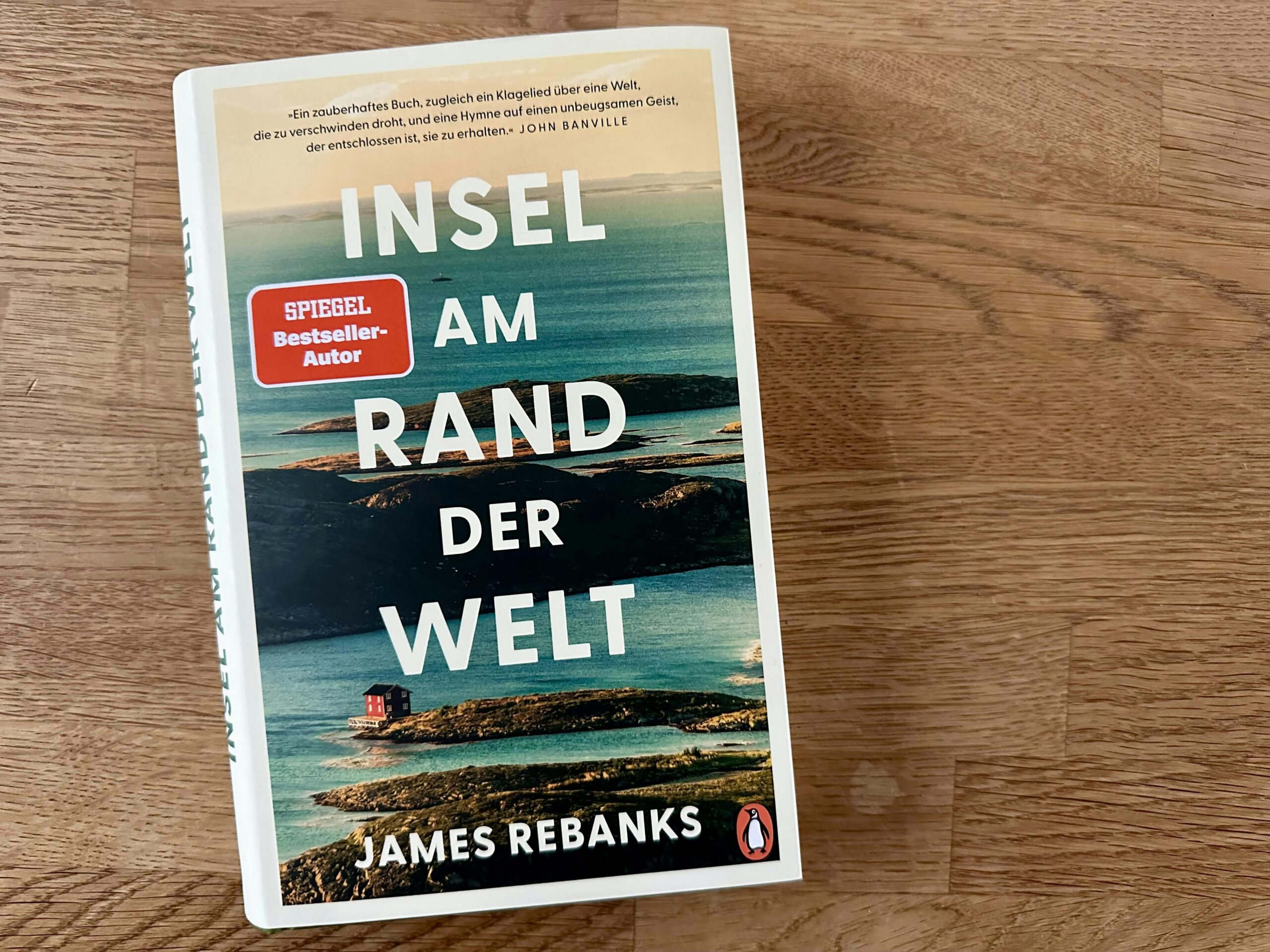 Buch "Insel am Rand der Welt" von James Rebanks auf einem Holztisch