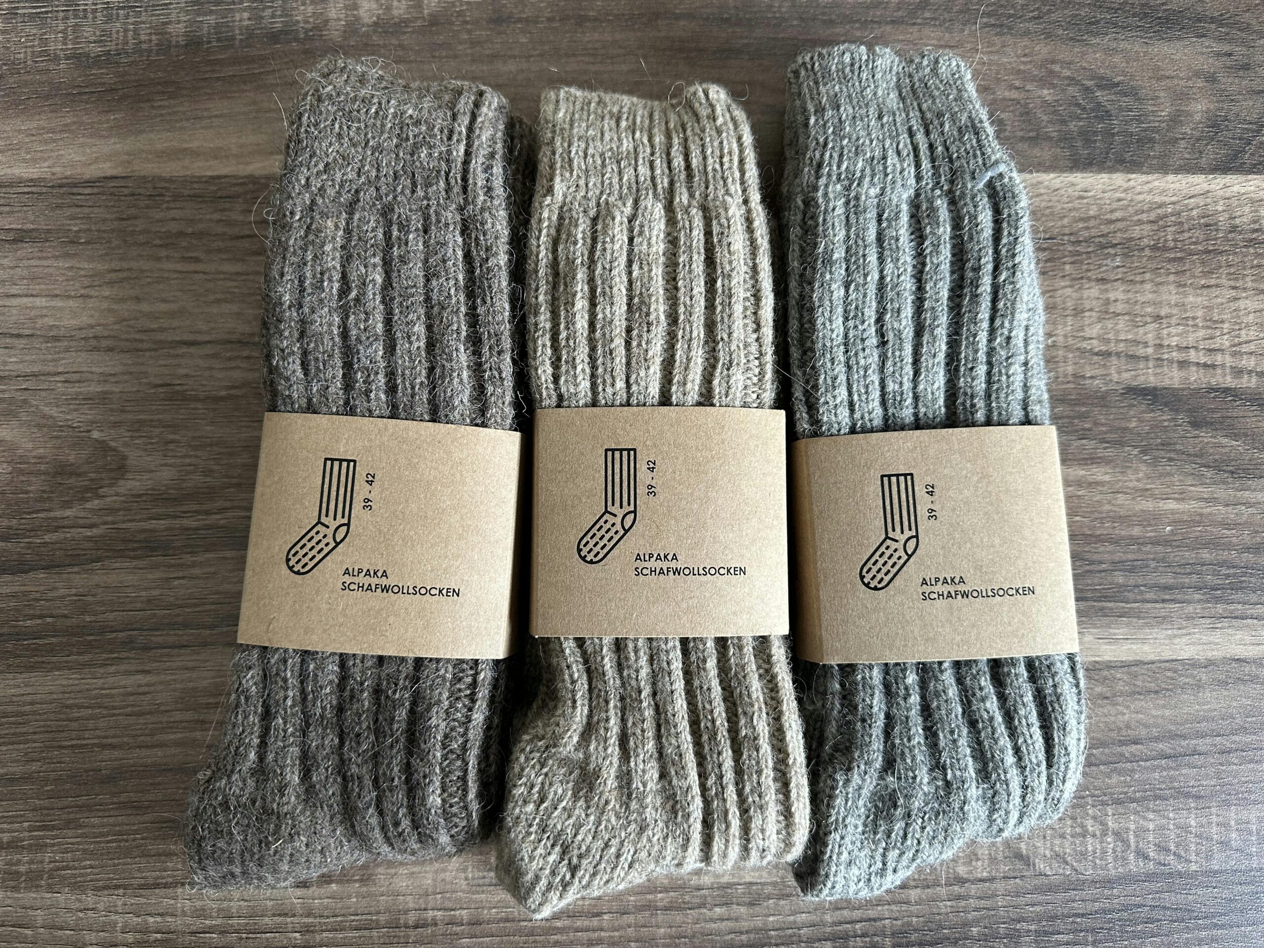 Drei Paar Wollsocken in grau-, beige- und braunmeliert.