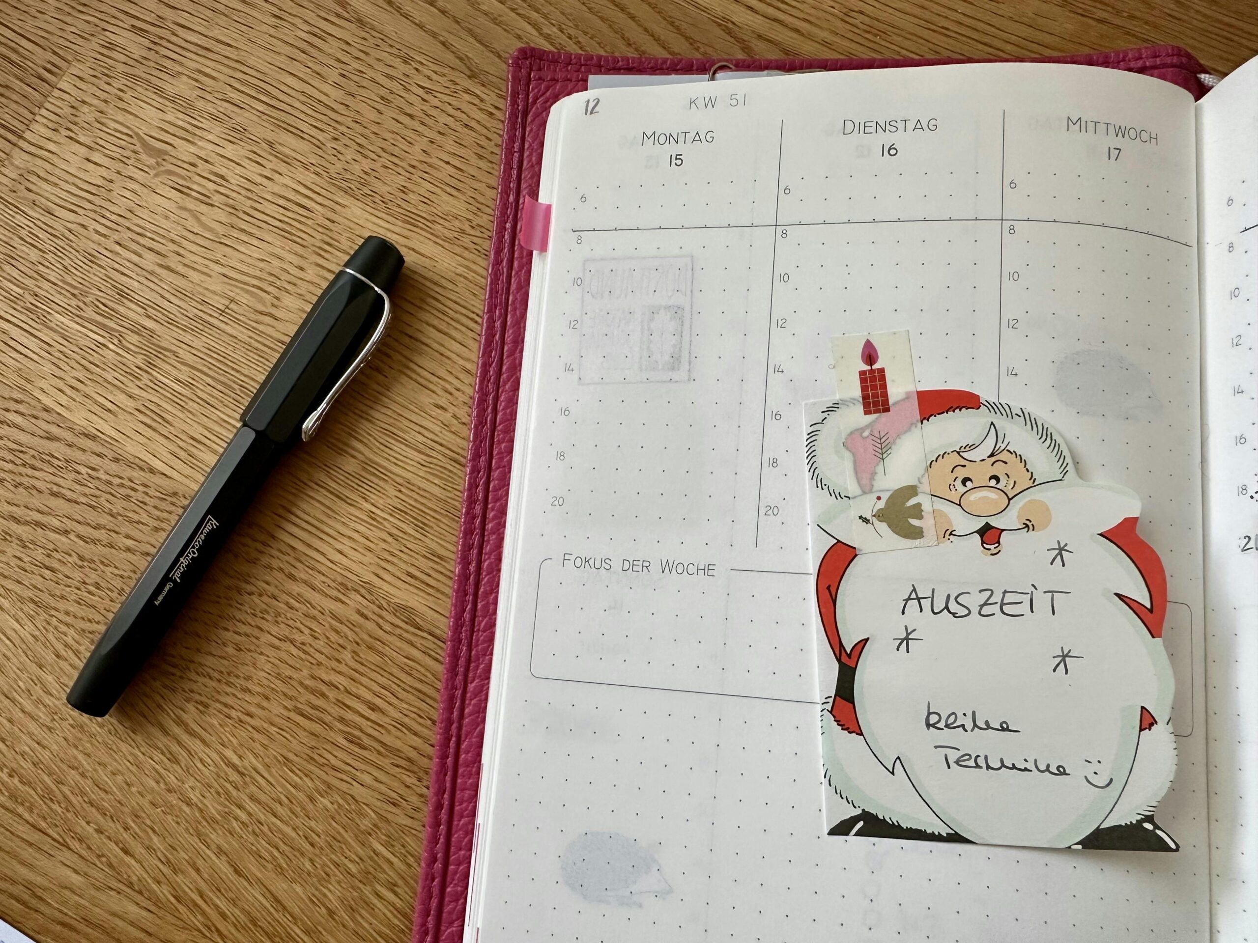 Leerer Kalender, der die Daten 15. bis 17. Dezember zeigt. Darauf klebt ein Notizzettel in Form eines Weihnachtsmannes, auf dem steht "Auszeit - keine Termine"