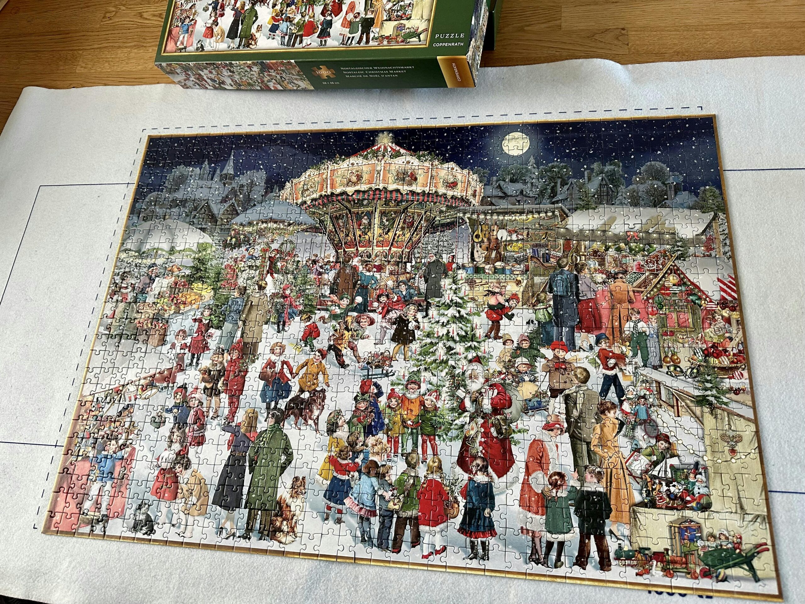 Puzzlematte auf einem Tisch, darauf das fertig gepuzzelte Puzzle "Nostalgischer Weihnachtsmarkt"
