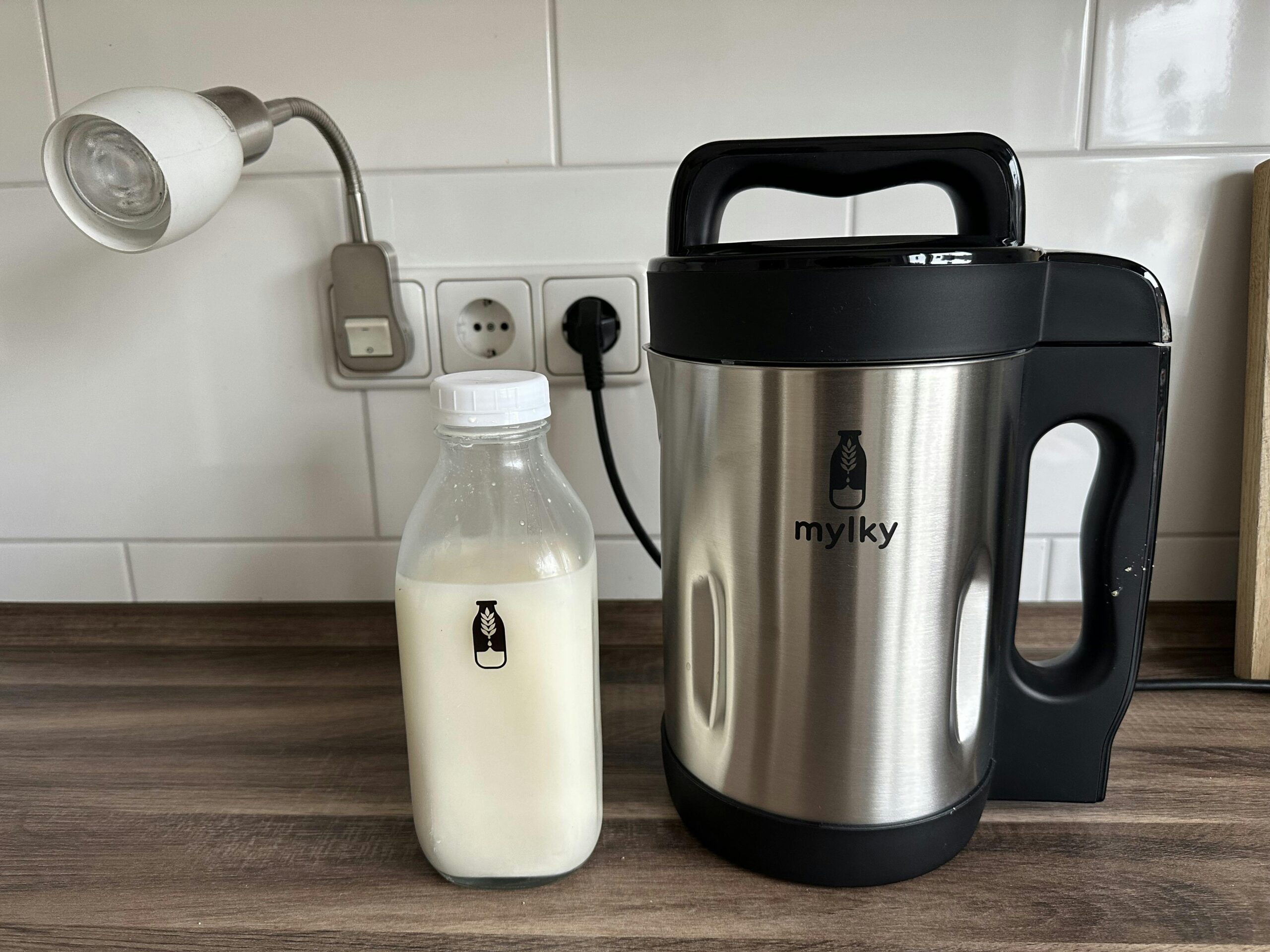 Mylky-Maschine neben einer Mylky-Glasflasche mit Hafermilch.