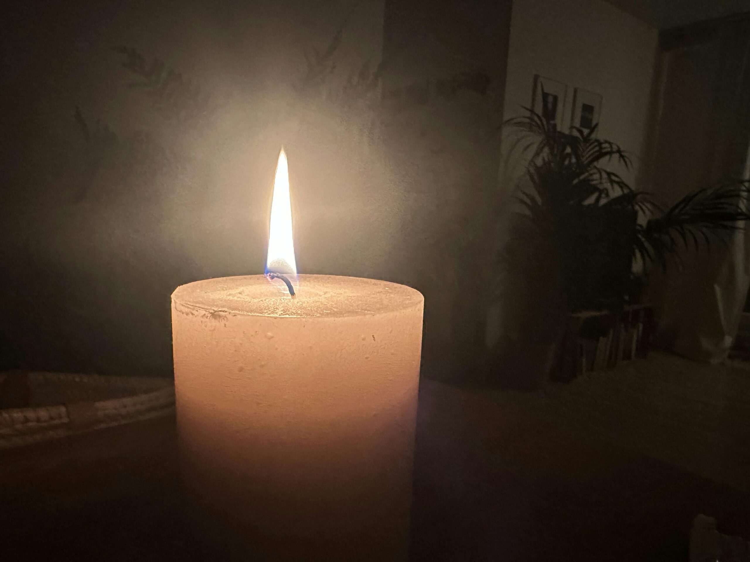 Brennende Kerze im dunklen Raum.